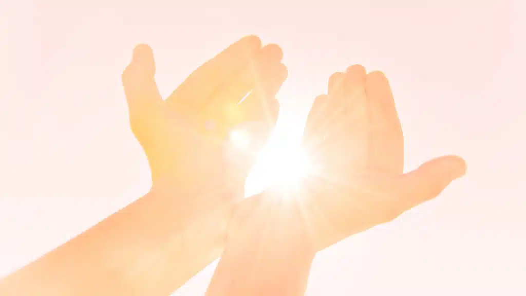 Les rayons du soleil traversant deux pommes de mains levées