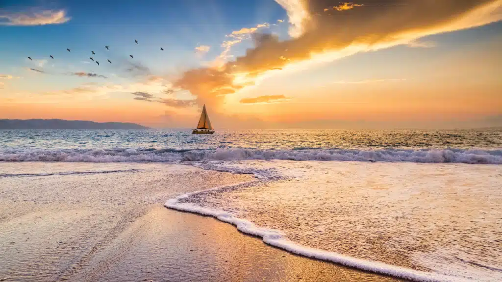 Un petit voilier sur la mer au coucher du soleil