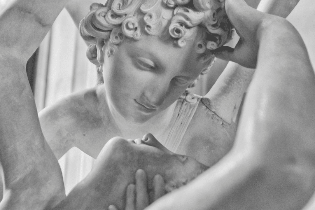 Une statue de pierre en train de regarder une autre statue dans ses bras